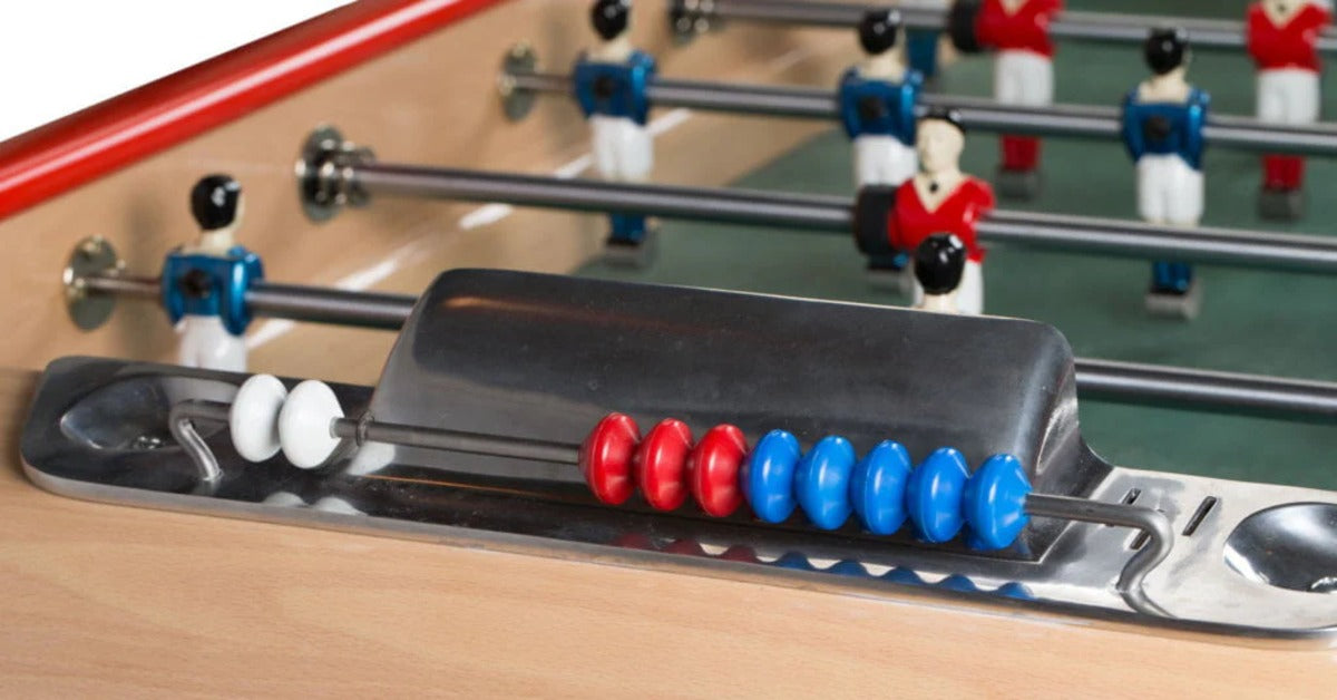 A foosball table score marker with red, blue, and white beads in front of rows of player figures on rods.